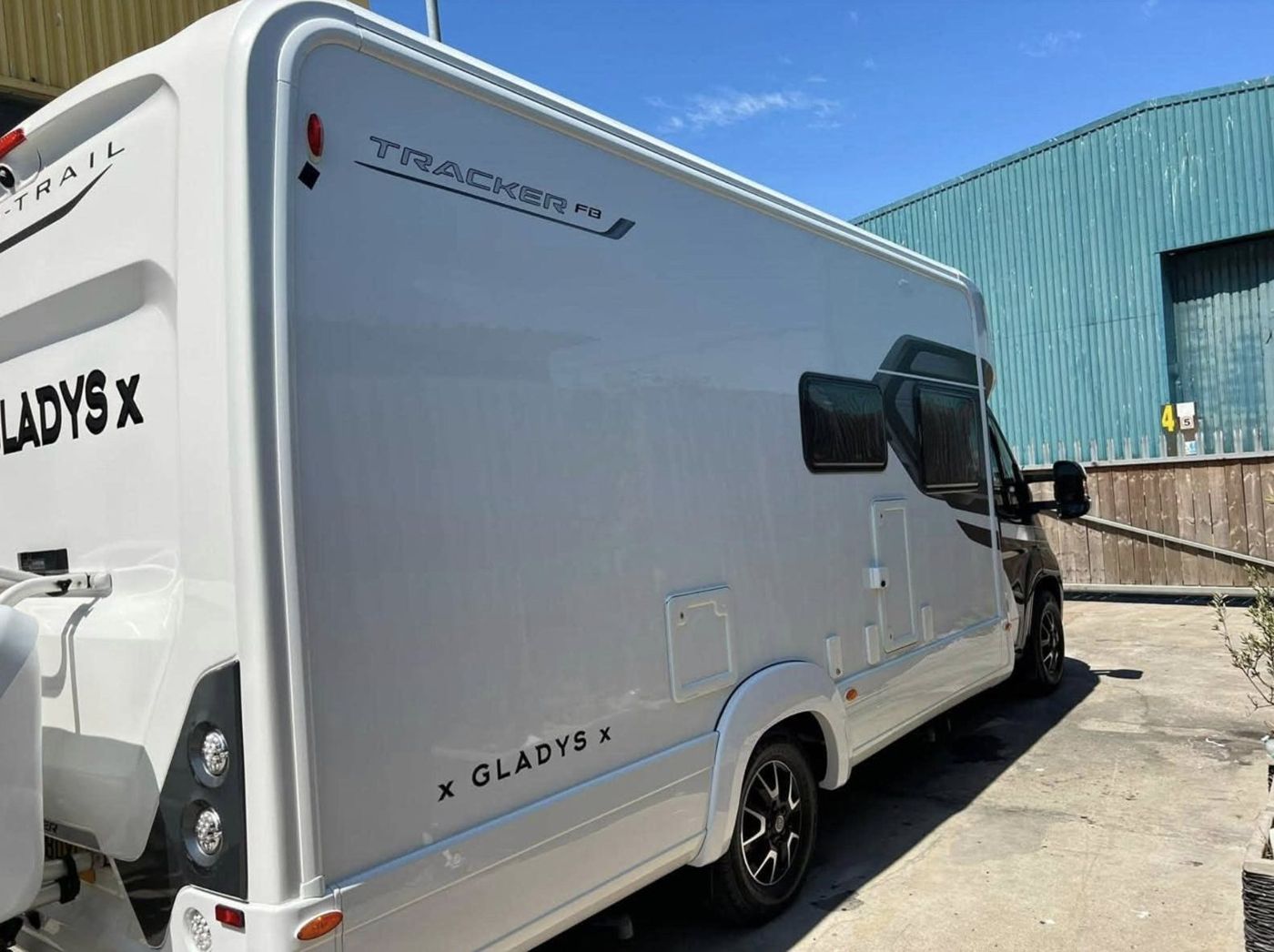 The side of a white motorhome in the sun